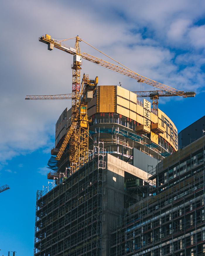 Services View of a skyscraper under construction with cranes in Bratislava, Slovakia.